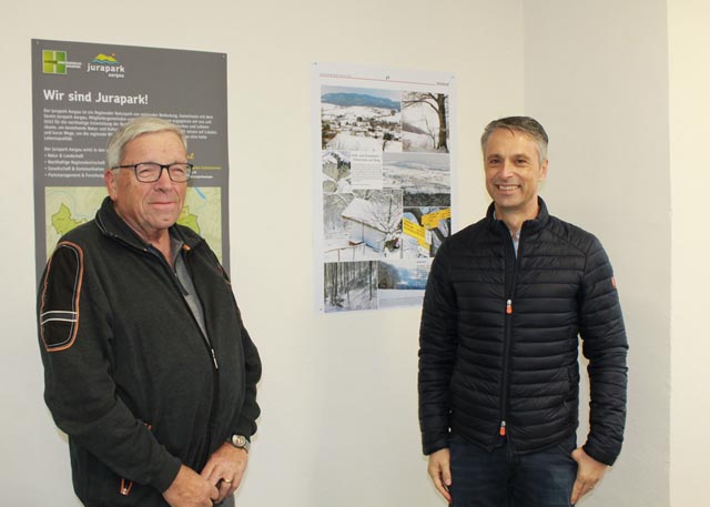 Auch der zukünftige Wölflinswiler Gemeindeammann Giuliano Sabato liess sich den Besuch der Bilderaustellung und einen Schwatz mit Peter Bircher nicht entgehen. Zwischen den beiden im Hintergrund die erste Bildseite von 2013. Foto: Sonja Fasler Hübner