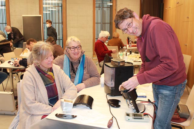 Der «Kaffee-Maschinen-Tisch»: Reparateur Heinz Krauter gibt alles, um die Kaffeemaschinen von Angela Cafaro (Mitte) und Claudia Käser (links) wieder zum Laufen zu bringen. Foto: Sonja Fasler