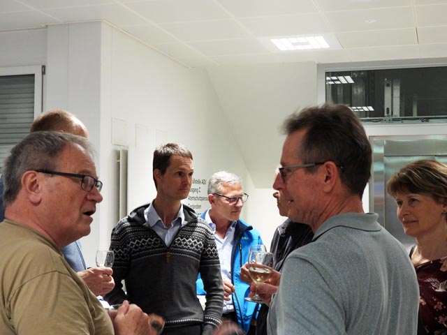 Referent Dr. Huss (mitte, im Pullover) im Gespräch beim Apéro. Foto: ofi