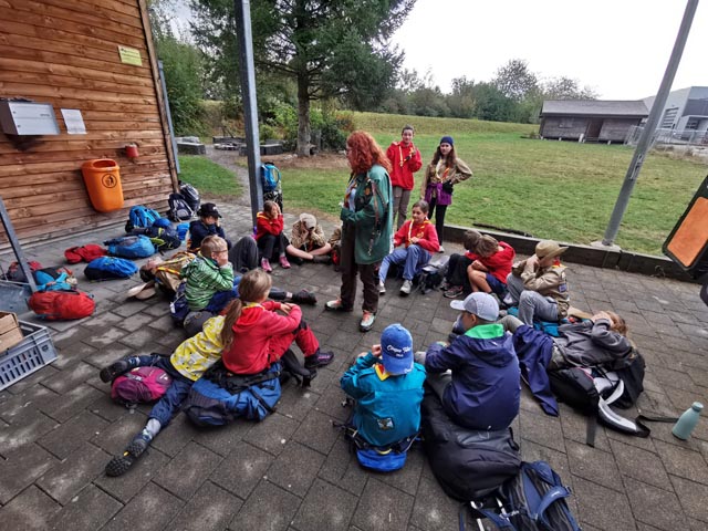 Wölfe und Pfader am Wewölfle (beliebtes Rätsel-Spiel) spielen, unter der Leitung von Piña (Mitte). Foto: zVg