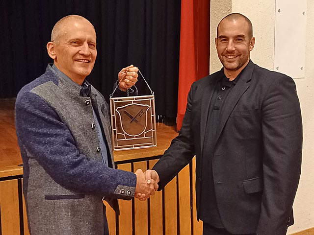 Gemeindeammann Benedikt Gürtler (links) überreicht dem langjährigen Gemeindeschreiber Marco Treier als Dank für seine Verdienste eine Obermumpfer Wappenscheibe. Foto: zVg