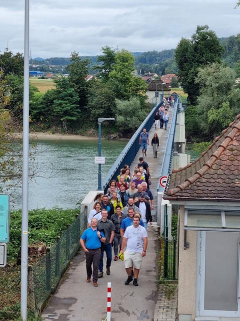 Die Helferinnen und Helfer des Fischessens überqueren die Zollbrücke. Foto: zVg