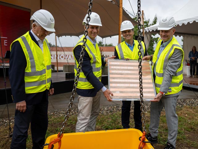 Von links: Projektdirektor Dr. Joachim Baeckert, Ivo Lansbergen, Business Unit President ANH, Nunzio Lo Chiatto CEO Berninvest und Werksleiter Dirk Dupper mit der Grundsteinplatte, bevor diese zusammen mit der Zeitkapsel per Kran in die Baugrube transportiert wurde. Foto: zVg