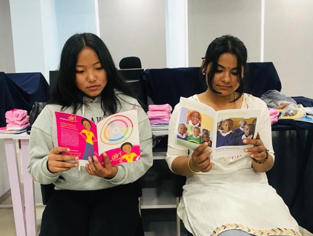 Internationaler Frauentag 2024: Zwei nepalesische junge Frauen lesen interessiert Broschüren, die im Rahmen des Projekts «Water and Pads for School Girls» erstellt wurden. Foto: zVg